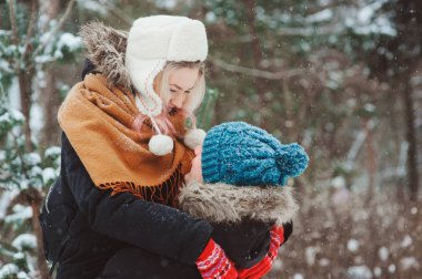 mutlu genç çift Noel süsleme, tatil açık harcama ile sıcak örme eldiven karlı kış ormanda yürüyüş