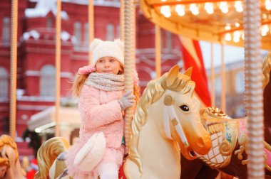 mutlu bir çocukluk kız Noel ve yeni yıl tatil eğlence parkı. Moskova Kızıl Meydan arka plan üzerinde