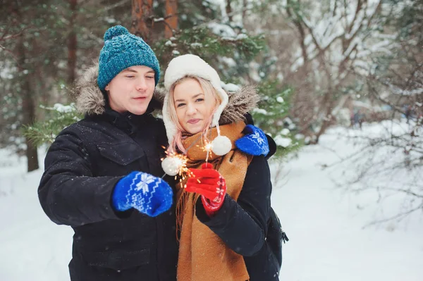 クリスマスの飾り 屋外の休暇の支出で暖かいニット手袋の冬の雪に覆われた森を歩く幸せな若いカップル — ストック写真