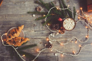 sıcak kakao marshmallows ve kruvasan Noel ışıkları rustik ahşap tablo. Sıcacık kış ev concept