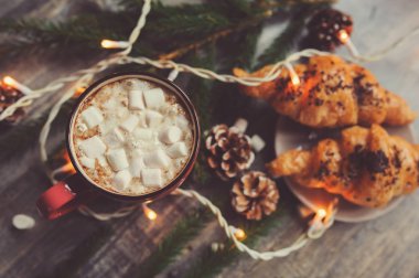 sıcak kakao marshmallows ve kruvasan Noel ışıkları rustik ahşap tablo. Sıcacık kış ev concept
