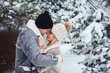 romantik çift öpüşme karlı ormanda kış portresi. Sevgililer günü veya tatil kavramı.