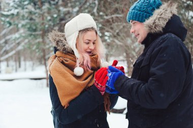 karlı kış ormanda yürüyüş, Noel hediyesi holding ve having fun mutlu genç sevgi dolu çift. Kış tatil kavramı.