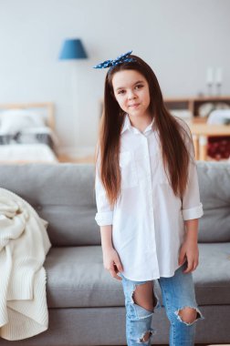 mutlu 10 yaşında çocuk ya da evde rahatlatıcı varoluş kız dikey portresi. Rahat oturma odası modern İskandinav iç, kendinizi evinizde gibi hissedeceğiniz yaşam konsepti ile. 