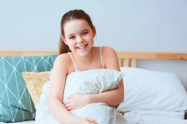 Szczęśliwa Dziewczyna Preteen Siedząc Łóżku Uściski Przytulne Poduszki Zdrowe Dziecko — Zdjęcie stockowe