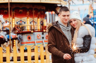 mutlu çift şehir tatil eğlence parkı, arka plan carousel yürüyüş Noel firelights ile