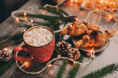 sıcak kakao marshmallows ve kruvasan Noel ışıkları rustik ahşap tablo. Sıcacık kış ev concept