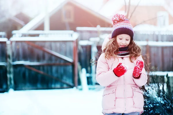 幸せな子女の子の雪に覆われた冬の庭屋外演奏します 季節の休日や休暇の概念 — ストック写真