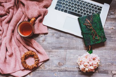 sonbahar ya da yaz rahat kazak, çay, Gözlük, eskiz defteri ve dizüstü masa üstü görünümüyle ahşap arka plan üzerinde Bahçe