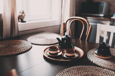 modern çiftlik evi ot yazlık kahverengi ve gri tonlarda rustik mutfakta. Sabah üzerinde ahşap masa kahve