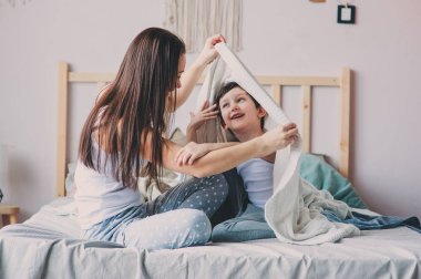 mutlu anne ve oğlu oynayan ve sıcak hafta sonu sabah yatakta battaniyenin altında saklanıyor. Gerçek aile ile rahat yaşam tarzı