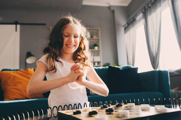 一个聪明的女孩在家里玩跳棋的生活方式拍摄 游戏的孩子的概念 坦诚系列与真实的人在现代内部 — 图库照片