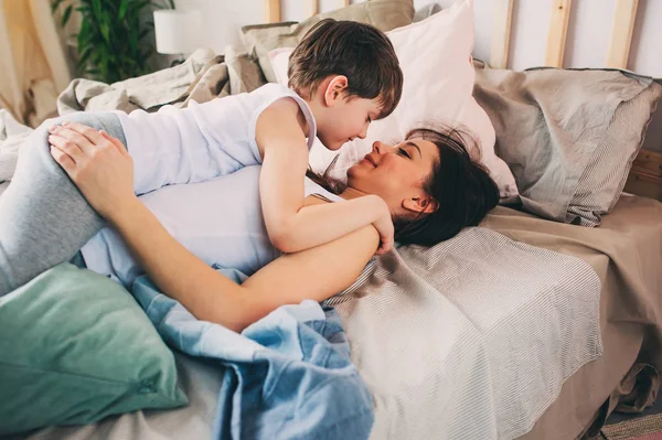 어머니는 집에서 침대에 아침에 그녀의 아들을 캐주얼 라이프 스타일 — 스톡 사진