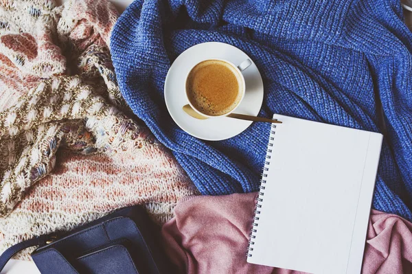 shopping list for winter sale with cup of coffee and cozy stylish sweaters