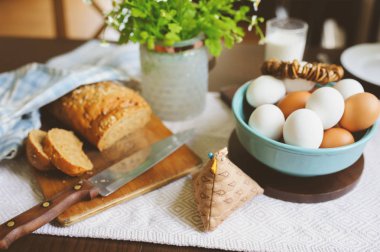 rustik ev mutfak çiftlik yumurta, tereyağı, kepekli ekmek ve süt ile ülke kahvaltı. Organik ev yapımı yiyecek, Paskalya kavramı.  