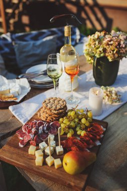 lezzetli peynir, jambon ve meyve ahşap kesme tahtası üzerinde yaz bahçe partisi üzerinde açık servis