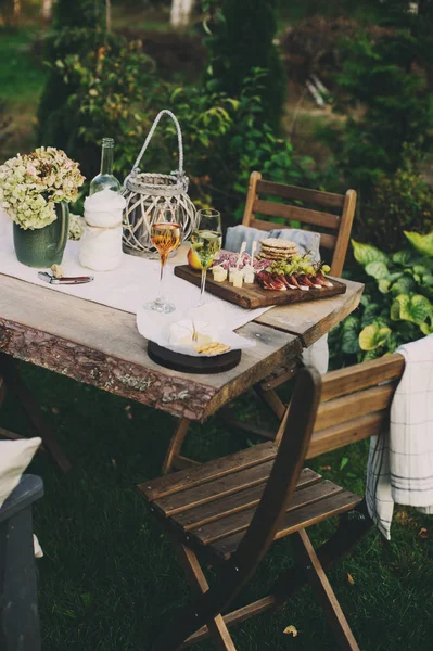 夏季花园餐桌装饰鲜花和蜡烛 晚上聚会与葡萄酒 奶酪和水果 — 图库照片