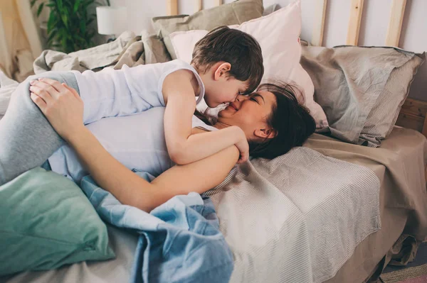 어머니는 집에서 침대에 아침에 그녀의 아들을 캐주얼 라이프 스타일 — 스톡 사진