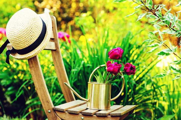 庭師の帽子に水をまくと木製の椅子は 美しいサマー ガーデン — ストック写真