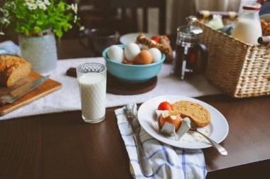 rustik ev mutfak çiftlik yumurta, tereyağı, kepekli ekmek ve süt ile ülke kahvaltı. Organik ev yapımı yiyecek, Paskalya kavramı.  