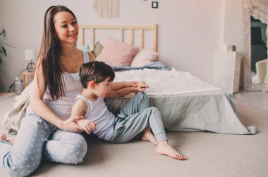 Genç mutlu anne çocuk evlat yatak odasında rahatlatıcı. Aile ilişkileri ve ebeveynlik kavramı, gündelik yaşam. 