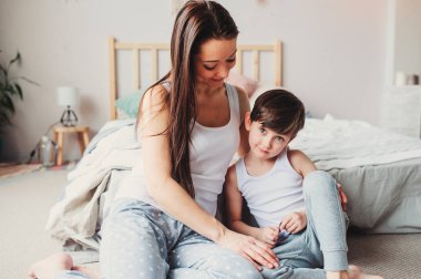Genç mutlu anne çocuk evlat yatak odasında rahatlatıcı. Aile ilişkileri ve ebeveynlik kavramı, gündelik yaşam. 
