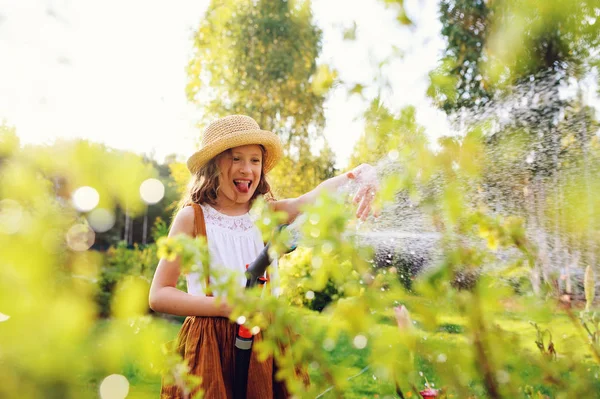 Счастливая Девочка Поливает Цветы Шланга Летнем Саду Проводит Водяной Разбрызгиватель — стоковое фото