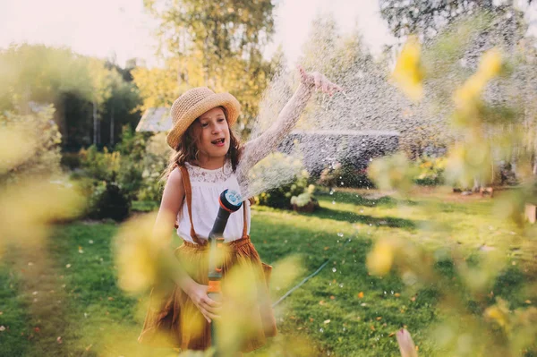 Lyckligt Barn Flicka Vattna Blommor Med Slang Sommarträdgården Hålla Vatten — Stockfoto