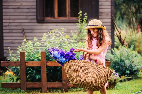 夏の庭から美しいブルーのデルフィ ニウム切り花の花束を選んで幸せな子女の子のロマンチックな肖像画 — ストック写真