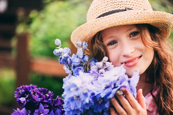 夏の庭から美しいブルーのデルフィ ニウム切り花の花束を選んで幸せな子女の子のロマンチックな肖像画 — ストック写真