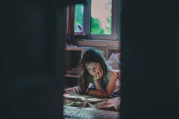 Niña Reflexiva Leyendo Libro Solo Habitación Veening Temprano Mañana — Foto de Stock