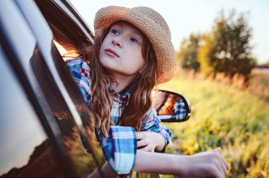 Mutlu çocuk yaz tatillerinde araba camından dışarı bakıyor. Yaz zamanı, yeni yerler kavramını keşfetmek.