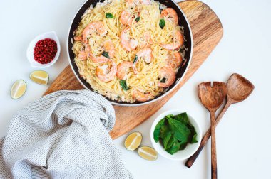 Tavanın üst görüntüsü, kremalı fesleğenli, pembe biberli, limonlu, beyaz arka planlı makarna. 