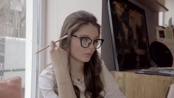Brunette Kaukasische vrouw met bril aan het werk in een café met laptop, 4K — Stockvideo
