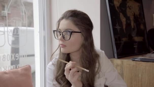 Nadenkend zakenvrouw weg op zoek naar idee tijdens het gebruik van laptop met koffie in het café — Stockvideo