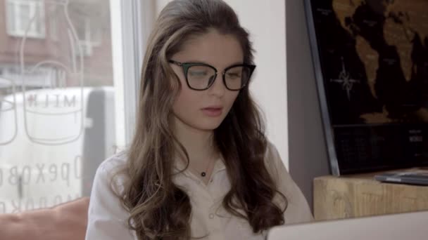 Student brunett tjej arbetar i café med laptop, 4k — Stockvideo