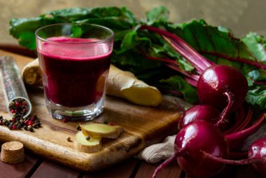 Ginger 'lı taze baharatlı pancar suyu, ahşap masanın üstünde taze pancar.