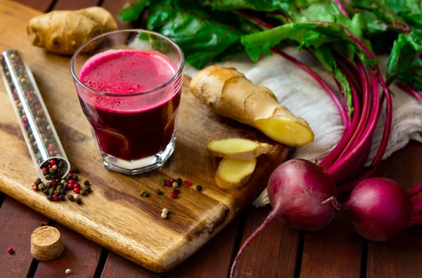 Ginger 'lı taze baharatlı pancar suyu, ahşap masanın üstünde taze pancar.