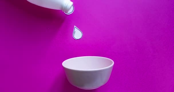 ボトルから注ぐミルクと面白いストップモーションアニメーション ピンクの背景に朝食のためにボウルに落ちるコーンフレーク — ストック動画