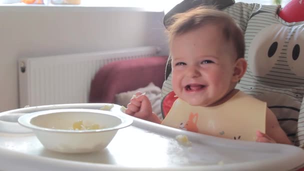 Cute baby eating cauliflower first time at home. Healthy child nutrition, Baby first solid feeding, baby 7 months in highchair eats by herself, self-feeding — Stock Video