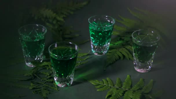 一个带有绿色苦艾酒的小杯 黑暗背景下的森林蕨类和美丽的阴影 — 图库视频影像