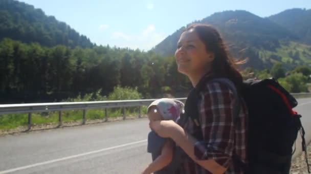 Traveler mom with baby hitchhiking σε ορεινό δρόμο. — Αρχείο Βίντεο