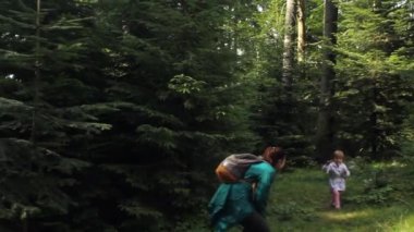 Çocuklu bir kadın gezgin ormanda yürüyor..
