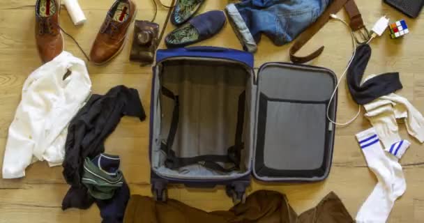 Η βαλίτσα ταξιδιού είναι γεμάτη με ανδρικά ρούχα και αξεσουάρ. Jet set concept — Αρχείο Βίντεο