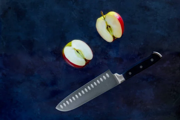 Rodajas de manzana roja cortadas con fruta Cuchillo sobre fondo oscuro. Levitación de alimentos y espacio de copia — Foto de Stock