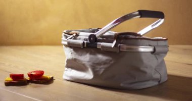 Bir piknik çantası yiyeceklerle doludur - sandviç, meyve, bir şişe şarap ve iki bardak. Hareketi durdur