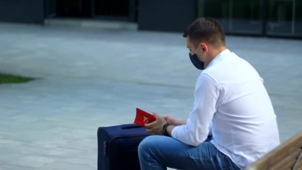 Tourist man in protective mask is sitting with boarding pass. Coronavirus COVID-19 and Travel concept. — Stock Video