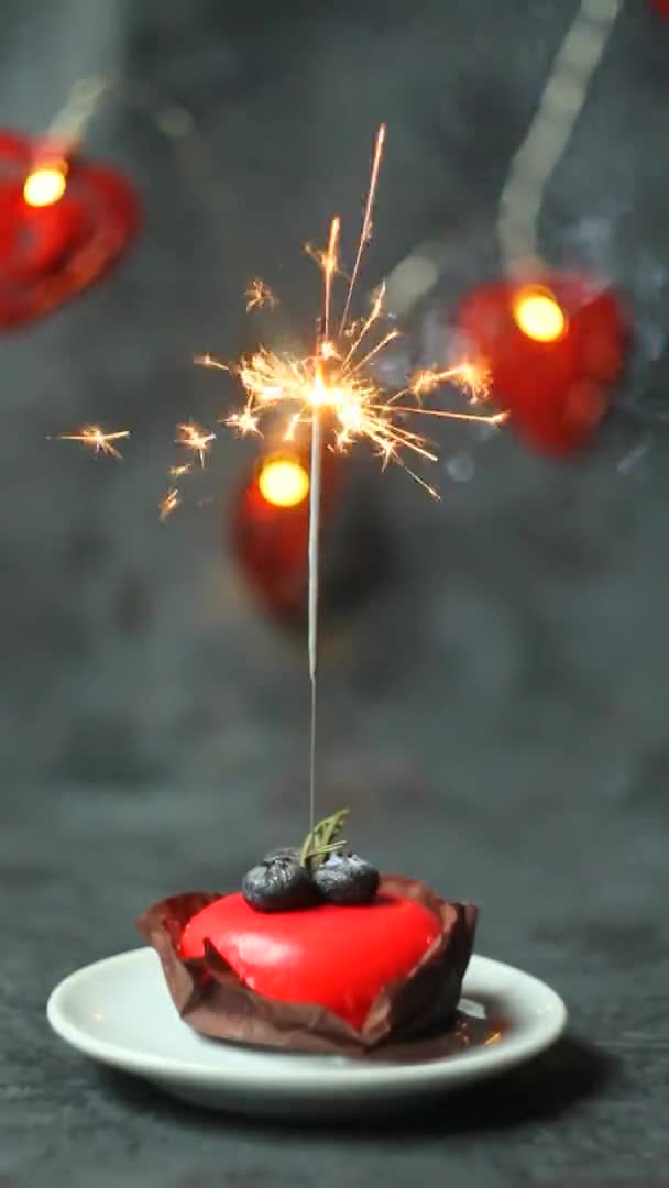 Dolce rosso festivo con sparkler in fiamme su sfondo scuro. orientamento verticale dello schermo. — Video Stock