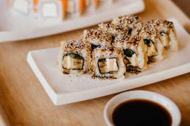 Philadelphia usulü suşi, salatalık, krem peynir, kırmızı havyar. Suşi menüsü.