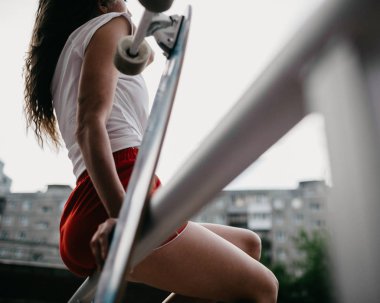 Kırmızı şortlu güzel bir kaykaycı kadın yaban domuzuna biniyor.